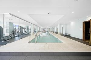 悉尼The Alexander Apartments - Harbour Views, Parking, Pool, 24hr Concierge的一座空洞的健身房,在一座大楼里设有一个游泳池
