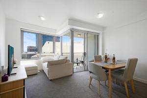 悉尼The Alexander Apartments - Harbour Views, Parking, Pool, 24hr Concierge的一间带桌子和沙发的客厅以及一间用餐室