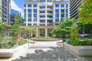 悉尼The Alexander Apartments - Harbour Views, Parking, Pool, 24hr Concierge的城市里种有长椅和树木的庭院