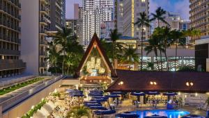 檀香山OUTRIGGER Reef Waikiki Beach Resort的享有带桌子和遮阳伞的度假村景色