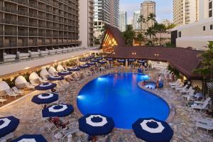 檀香山OUTRIGGER Reef Waikiki Beach Resort的享有酒店泳池的顶部景色,配有蓝色遮阳伞