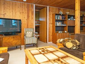 里伯6 person holiday home in Ribe的客厅配有电视、沙发和桌子