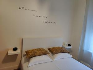 卡尔卡松L'appart du Canal的卧室配有一张墙上写着字条的床