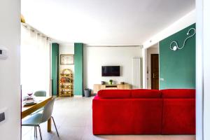 比萨Hostly - Cisanello Suite Apartment - Light and Colors的客厅配有红色的沙发和桌子
