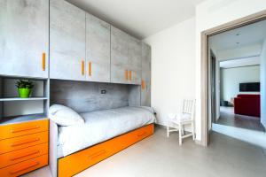 比萨Hostly - Cisanello Suite Apartment - Light and Colors的一间卧室配有一张带橙色抽屉和橱柜的床。
