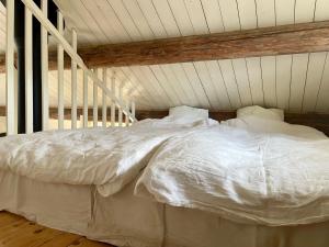 法尔雪平Backgårdens Timmerstuga的一张带白色床单和枕头的床