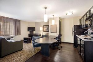 欧文Sonesta Simply Suites Dallas Las Colinas的一间客厅,客厅内配有桌椅
