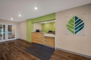 卫斯理堂WoodSpring Suites Wesley Chapel-Tampa的空空的办公室,拥有绿色和白色的墙壁,铺有木地板