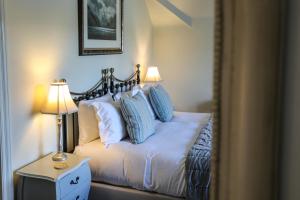 雷文斯通代尔黑天鹅酒店的一间卧室配有一张带蓝色和白色枕头的床