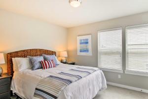 洋滨市Ocean Shores House with Hot Tub - Walk to Beach的一间卧室设有一张床和两个窗户。