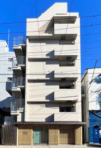 东京KLASSO Tokyo Sumiyoshi Apartments的白色的建筑,旁边设有阳台