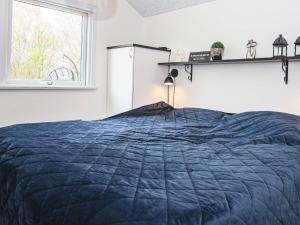 SønderbyHoliday home Sydals LXXVII的一间卧室设有蓝色的床和窗户。