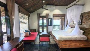 Làng BangAmigo Pu Luong的一间卧室设有一张大床和一张红色长凳