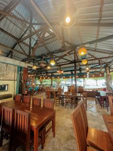 TanjungbingaRock and Wreck Dive Resort的用餐室配有木桌和椅子