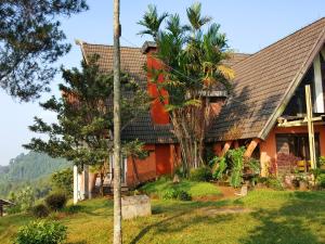 希维德Argapuri Jungle Resort Ciwidey的前面有棕榈树的房子