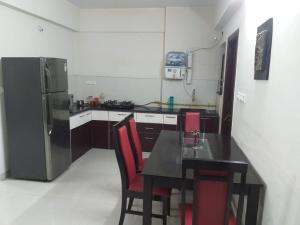 印多尔executive rooms @ indore-mp.的厨房配有黑桌和冰箱。