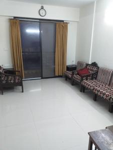 印多尔executive rooms @ indore-mp.的客厅设有两张沙发和墙上的时钟