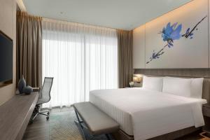 新加坡Dusit Thani Laguna Singapore的酒店客房设有一张白色大床和一张书桌