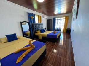 普罗维登西亚Posada Ashanty的一间设有两张蓝色和黄色床铺的客房