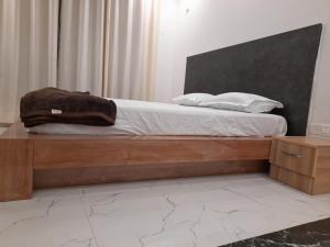 BegusaraiAshoka Resort & Banquets的一间卧室配有一张带木制床架的床
