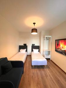 派尔努Centre Premium的一张沙发和一台电视机的客房内的两张床