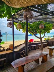 蓝梦岛乐伯甘马德旅馆的海滩上带桌椅的木制甲板