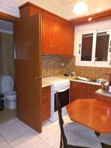 卡尔季察Ιάνθη studio的厨房配有木制橱柜、桌子和水槽。