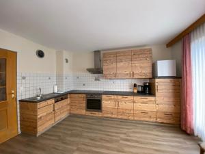 列兴Ferienhaus Bergwelt的厨房配有木制橱柜和黑色台面