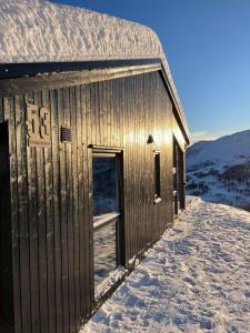 松达尔Cabin at the top of Hodlekve. Ski in/ski out.的一座有雪的木结构建筑