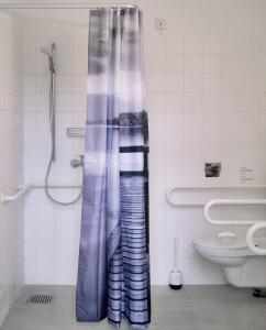 柏林Motel Home Wittenau的设有带卫生间的浴室内的淋浴帘