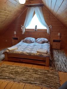 扎沃亚Domek drewniany simonka zawoja的小木屋内的一张床位,设有窗户