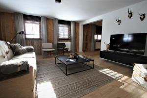 贝旺Alpin Haus Berwang的带沙发和平面电视的客厅