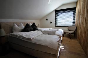 贝旺Alpin Haus Berwang的一间卧室配有带白色床单和枕头的床。