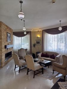 马达巴Mariam Hotel的客厅配有沙发、椅子和壁炉