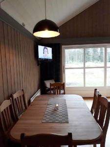 特吕西尔14-Nasjonalpark, sykling, fisking, kanopadling, skogs- og fjellturer的一间带木桌和电视的用餐室