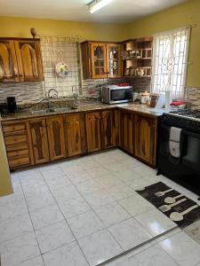 圣玛丽Seaview Villa的厨房配有木制橱柜和炉灶烤箱。