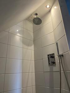 KapelleTorenzicht的带淋浴的浴室和白色瓷砖墙