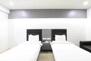 艾哈迈达巴德Alba Premier, Ahmedabad的白色墙壁客房的两张床