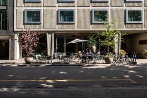 巴塞尔游牧设计与生活方式酒店的一群坐在大楼外桌子上的人