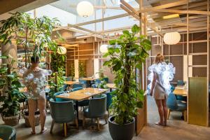 巴塞尔游牧设计与生活方式酒店的两个人站在植物餐厅里