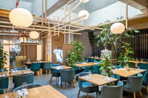 巴塞尔游牧设计与生活方式酒店的餐厅设有木桌和蓝色椅子