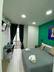 那不勒斯2Naples Rooms的一间卧室配有一张带绿色墙壁的床