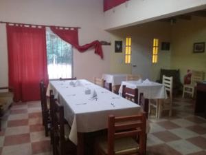 乌尼翁镇HOTEL FINCA AMANCAY的一间带桌椅和红色窗帘的用餐室