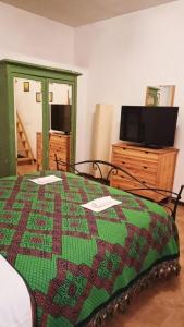 皮蒂利亚诺La casa di sally的一间卧室,床上有被子,还有一台电视机