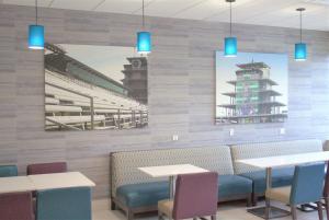 印第安纳波利斯La Quinta Inn & Suites by Wyndham Indianapolis Downtown的一间带桌椅的餐厅,以及一幅体育场画