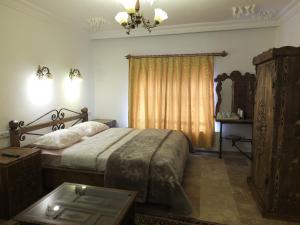 格雷梅Anatolia cave hotel Pension的一间卧室配有一张床、一张桌子和一个窗户。