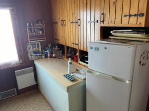 Ban-sur-Meurthe-ClefcyChalet situé au grand Valtin的厨房配有白色冰箱和木制橱柜。