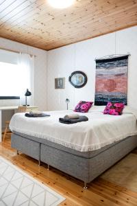 AlajärviLepikko - Helppoa majoitusta, Easy accommodation的卧室内的一张大床,拥有木制天花板