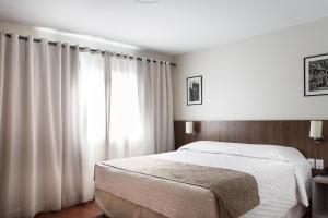 圣玛丽亚Hotel Dom Rafael Premium的卧室配有白色的床和窗户。