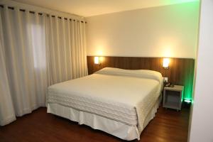 圣玛丽亚Hotel Dom Rafael Premium的一间卧室配有一张带白色床单的大床
